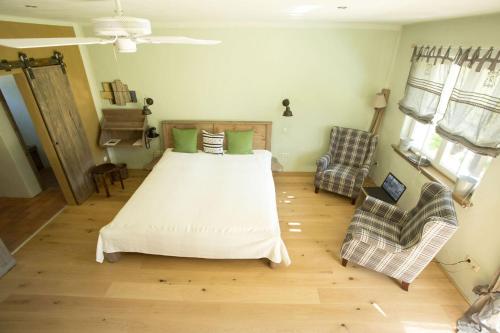 a bedroom with a large bed and two chairs at Hotel Kolonieschänke in Burg