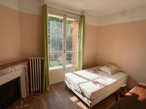 une petite chambre avec un lit et une fenêtre dans l'établissement Au calme, à Saint-Sylvain