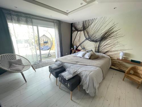 une chambre avec un lit avec un tableau sur le mur dans l'établissement Gîte Les Eaux du Moulin piscine chauffée et jacuzzi, à Vittefleur