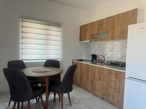 a kitchen with a table and chairs and a refrigerator at Madavajo in Petrovac na Mlavi