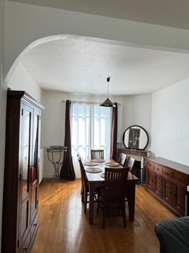 une salle à manger avec une table et des chaises dans une pièce dans l'établissement Maison individuelle avec jardin, à Aulnay-sous-Bois