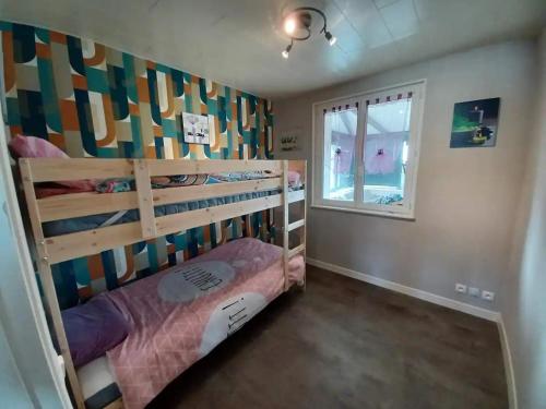 une chambre avec un lit superposé et une fenêtre dans l'établissement Maison bord de mer, à Saint-Germain-sur-Ay