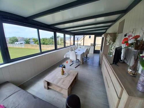 Cette grande chambre comprend une table, des bancs et des fenêtres. dans l'établissement Maison bord de mer, à Saint-Germain-sur-Ay