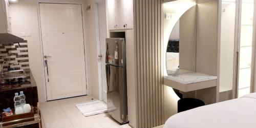 a bathroom with a sink and a refrigerator in a room at Altiz Bintaro Studio Exclusive 1 in Pondoklang
