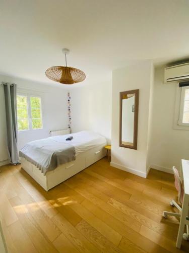 une chambre blanche avec un lit et un miroir dans l'établissement Magnifique villa avec jardin proche centre ville, climatisé, à Aix-en-Provence