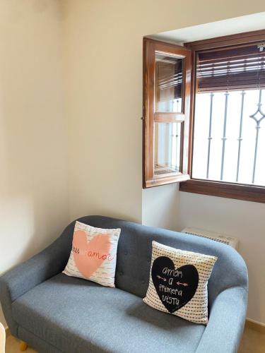 a blue couch in a living room with a window at Apartamentos Peñaflor in Guadix
