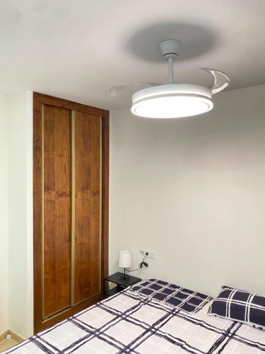 a white room with a bed and a light at Apartamentos Peñaflor in Guadix