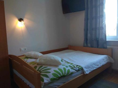 a bed with two pillows on it in a bedroom at Apartament i pokoje na Sosnowej in Ostrowo