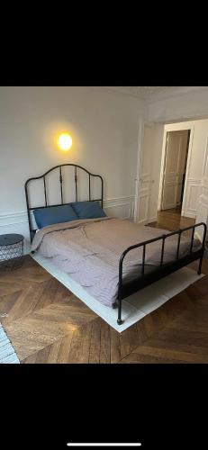 une chambre avec un grand lit avec des oreillers bleus dans l'établissement Room in large classic Parisian apartment, à Paris