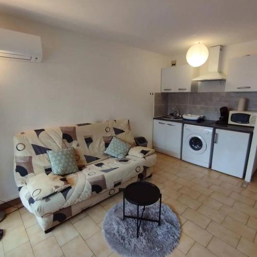 un salon avec un canapé et une cuisine dans l'établissement studio climatisé vue sur mer, réservation du samedi au samedi, à Canet