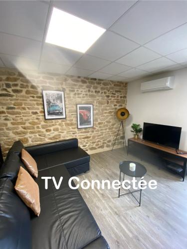 un salon avec un canapé et une télévision dans l'établissement Les Pichies, T2 Gloria, centre ville, à Digoin