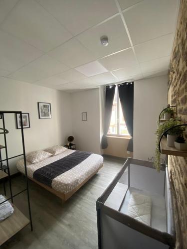 une chambre avec un lit et une fenêtre dans l'établissement Les Pichies, T2 Gloria, centre ville, à Digoin