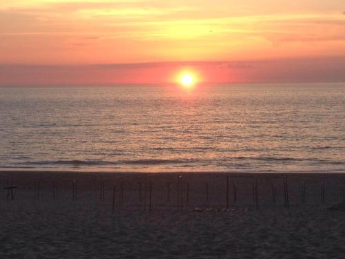 - un coucher de soleil sur la plage avec l'océan dans l'établissement baletti, à Saint-Vivien-de-Médoc