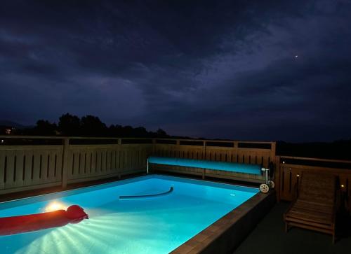 a swimming pool on a balcony at night at Apartman Ferenac in Ozalj