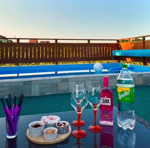 a table with two glasses and a bottle of wine at Apartman Ferenac in Ozalj