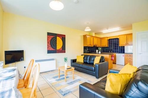 a living room with a couch and a kitchen at 56 - Three Bed Apartment With Parking in Galway