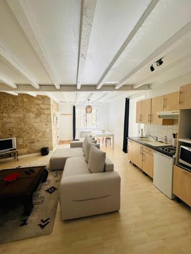 un salon avec un canapé blanc et une cuisine dans l'établissement Appartement Au Cœur Du Centre Historique, à Périgueux