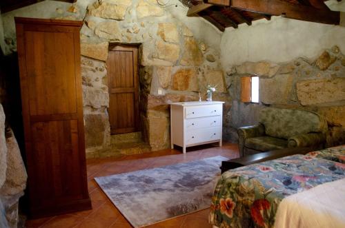 a bedroom with a bed and a stone wall at Bosque Encantado in Beire