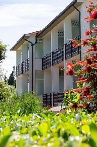 a building with balconies and red flowers in the foreground at Eden Park Hotel in Marina di Campo