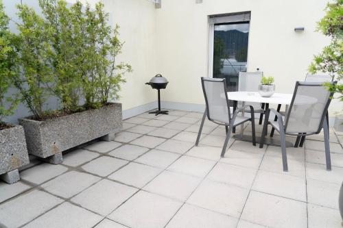 a patio with a table and chairs and plants at Terrace Apartment Einigen in Einigen