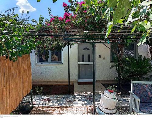 a pergola with flowers on top of a house at Εξοχικό MARIA in Ambelákia