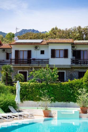 a resort with a swimming pool and a building at Eden Park Hotel in Marina di Campo