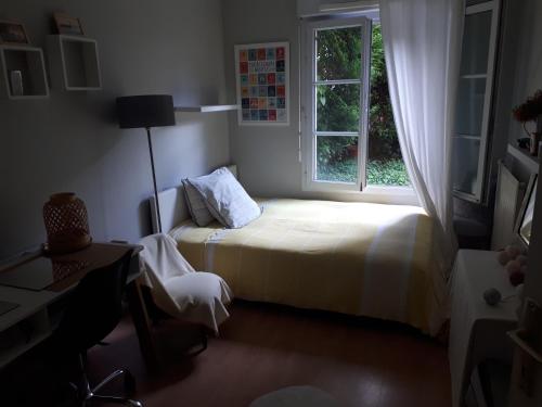une petite chambre avec un lit et une fenêtre dans l'établissement Appartement Le Plessis-Robinson, au Plessis-Robinson