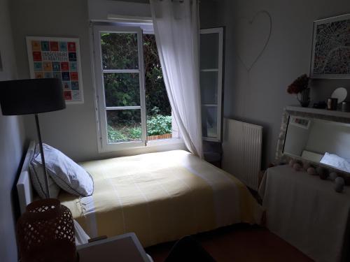 une petite chambre avec un lit et une fenêtre dans l'établissement Appartement Le Plessis-Robinson, au Plessis-Robinson