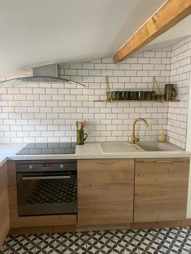 une cuisine avec une cuisinière et un évier dans l'établissement Chez Eric et Jess, à Narbonne