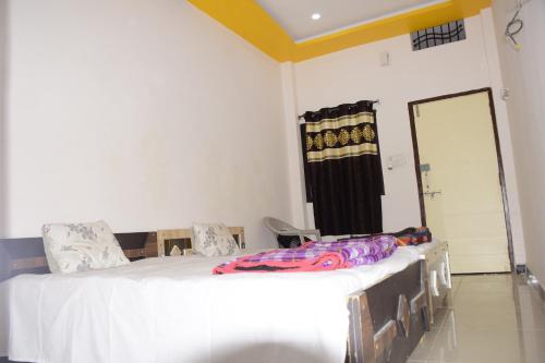 a bedroom with two beds and a door to a closet at Gurudham Guest house in Ujjain