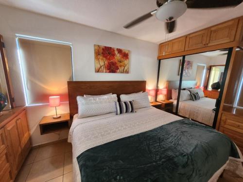 a bedroom with a large bed and a mirror at Beach Eateries Shops 10 min walk Golf view in San José del Cabo