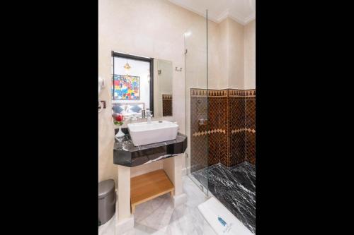 a bathroom with a sink and a shower at Riad Atlas Palace & SPA in Marrakech