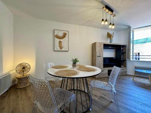 une salle à manger avec une table et des chaises dans une pièce dans l'établissement Le Logis de la Cathédrale, à Béziers