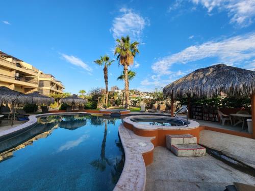 a pool at a resort with palm trees at Beach Eateries Shops 10 min walk Golf view in San José del Cabo