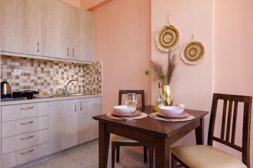 a kitchen with a table with two chairs and a sink at Ariadne Apartments in Kato Gouves