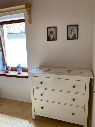a bedroom with a dresser and two pictures on the wall at Rusínska chyža in Ulič