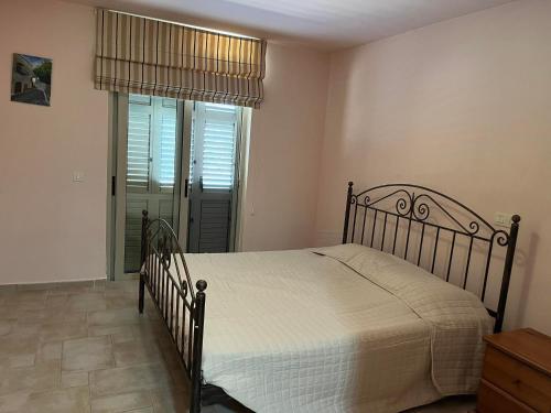 a bedroom with a bed and a window and a door at Avakas Sunset Villa in Paphos City