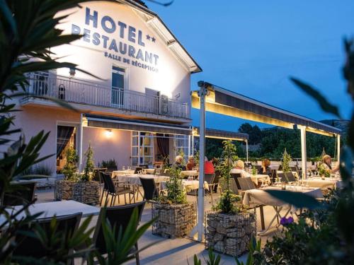 un restaurant avec des tables et des chaises devant un bâtiment dans l'établissement Villa provençale 3 chambres, à La Bégude-de-Mazenc