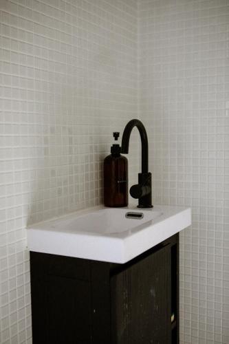 a sink with a soap dispenser on top of it at VILLA Centre Guethary piscine acces ocean a pied in Guéthary