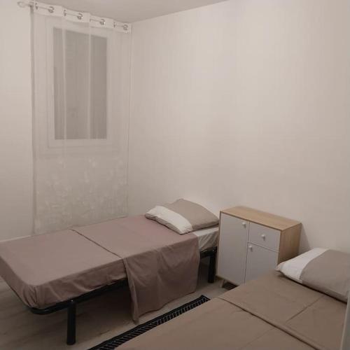 une chambre avec trois lits et une petite armoire dans l'établissement Loue appartement spacieux et familiale à marignane, La Galagoviere, 8 rue de Wolfsburg, à Saint-Victoret