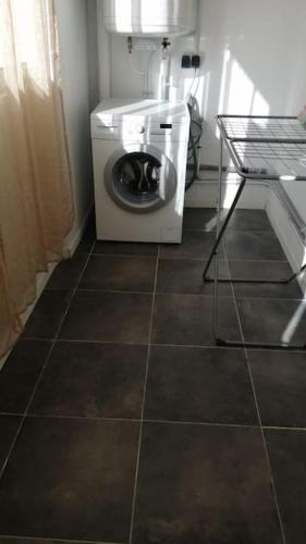 - un lave-linge dans une chambre revêtue de carrelage dans l'établissement Loue appartement spacieux et familiale à marignane, La Galagoviere, 8 rue de Wolfsburg, à Saint-Victoret