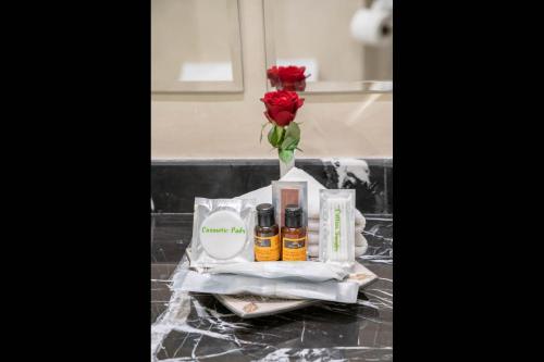 a vase with a rose and three products on a counter at Riad Atlas Palace & SPA in Marrakech