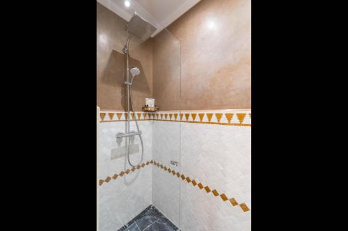 a bathroom with a shower with a glass door at Riad Atlas Palace & SPA in Marrakech