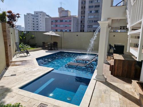 a swimming pool with a fountain on top of a building at Suíte privativa em lindo casarão in Sao Paulo