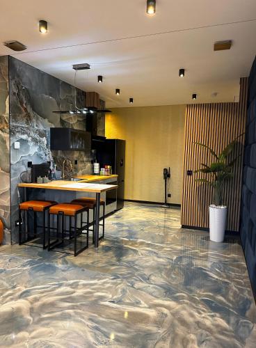 a kitchen with a marble floor and a table with stools at Luxe appartement dichtbij centrum D in Drachten