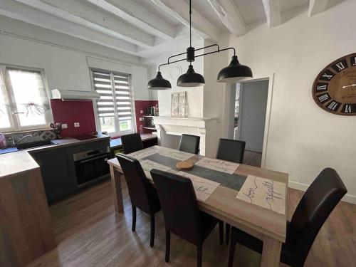 une cuisine et une salle à manger avec une table et des chaises dans l'établissement Logement La chartre sur le Loir 75m2, à La Chartre-sur-le-Loir