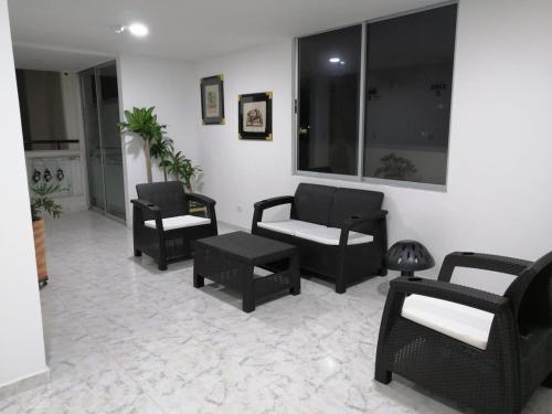 a living room with chairs and a table at Apartamento con la mejor ubicación y descanso in Armenia