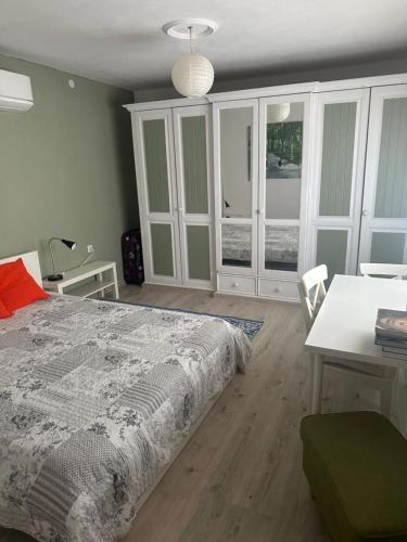 a bedroom with a bed and a desk and a table at Chez le Colonel Pool House in Dobromirka