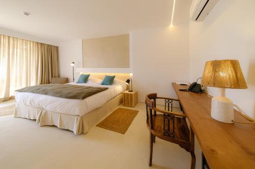 a bedroom with a bed and a desk with a lamp at Sorraia Hotel Rural in Santa Justa