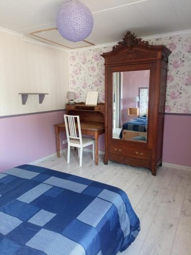 une chambre avec un lit, un bureau et un miroir dans l'établissement Petite maison toute équipée, au calme entre la mer et la campagne, à Fresney-le-Puceux